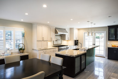 Example of a large trendy u-shaped ceramic tile eat-in kitchen design in San Francisco with a farmhouse sink, shaker cabinets, white cabinets, granite countertops, white backsplash, ceramic backsplash, stainless steel appliances and an island