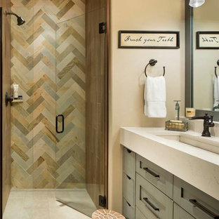 Alcove shower - mid-sized rustic master slate tile and multicolored tile porcelain floor and beige floor alcove shower idea in Denver with shaker cabinets, beige walls, quartz countertops, a hinged shower door, beige countertops, gray cabinets and a trough sink