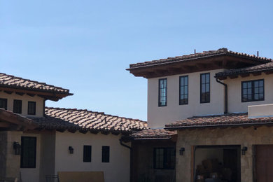 Example of a two-story house exterior design in Santa Barbara with a tile roof and a red roof