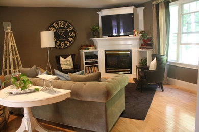 Immagine di un soggiorno tradizionale di medie dimensioni con pareti verdi, parquet chiaro, camino classico, parete attrezzata e pavimento marrone