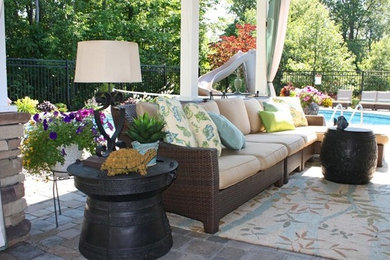 Mid-sized transitional backyard tile patio photo in Cleveland with a roof extension