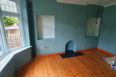 This is an example of a medium sized classic kitchen/dining room in London with blue walls, painted wood flooring, orange floors, a drop ceiling and a feature wall.
