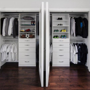 Example of a mid-sized classic gender-neutral medium tone wood floor reach-in closet design in San Francisco with flat-panel cabinets and white cabinets