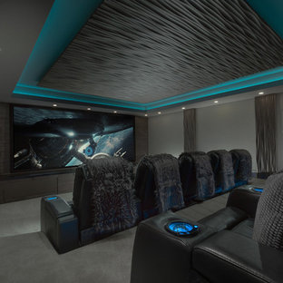 Inspiration for a large modern enclosed carpeted and gray floor home theater remodel in Salt Lake City with brown walls and a projector screen