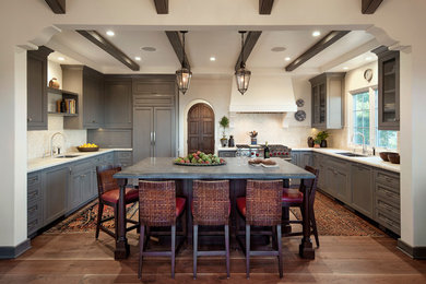 Example of a mid-sized tuscan u-shaped dark wood floor eat-in kitchen design in Santa Barbara with an undermount sink, shaker cabinets, gray cabinets, quartzite countertops, beige backsplash, ceramic backsplash, paneled appliances and an island