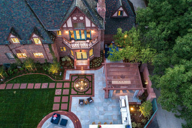 Inspiration for a huge timeless backyard stone patio kitchen remodel in Denver with a pergola
