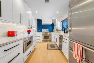 Inspiration for a limestone floor kitchen remodel in Los Angeles with a farmhouse sink, shaker cabinets, white cabinets, quartzite countertops, beige backsplash, ceramic backsplash, stainless steel appliances and beige countertops
