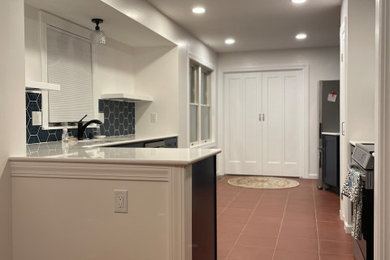 Small elegant ceramic tile and red floor kitchen photo in Other with an undermount sink, shaker cabinets, blue cabinets, quartzite countertops, blue backsplash, ceramic backsplash, stainless steel appliances, an island and white countertops