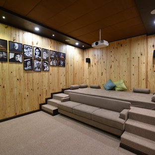 Photo of a contemporary enclosed home cinema in Other with brown walls, carpet, a projector screen and grey floors.