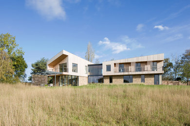 Modelo de fachada de casa gris minimalista con tejado a dos aguas y panel y listón