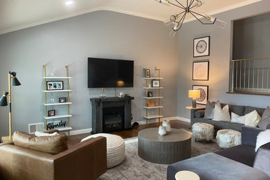 Living room - mid-sized contemporary open concept dark wood floor, brown floor and vaulted ceiling living room idea in New York with gray walls, a standard fireplace, a wood fireplace surround and a wall-mounted tv