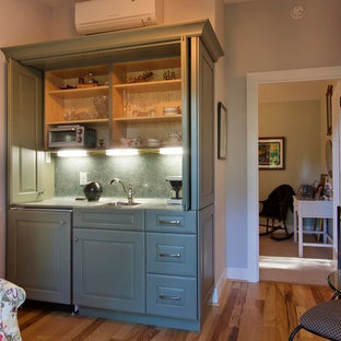 Small eclectic single-wall wet bar in Other with raised-panel cabinets and light hardwood floors.