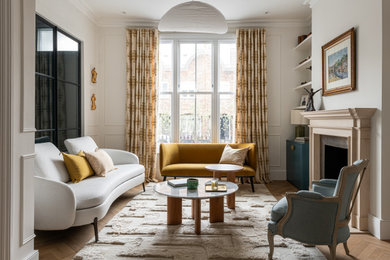Large contemporary formal enclosed living room in London with beige walls, light hardwood flooring, a ribbon fireplace, a stone fireplace surround, no tv, beige floors, panelled walls and a chimney breast.