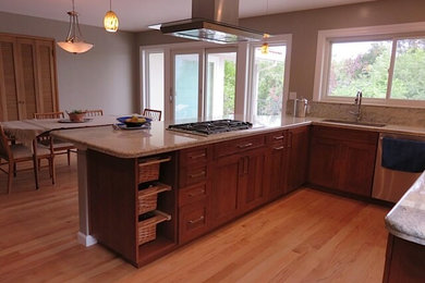 Example of a large trendy u-shaped light wood floor eat-in kitchen design in San Francisco with an undermount sink, shaker cabinets, dark wood cabinets, granite countertops, stone slab backsplash, stainless steel appliances and a peninsula