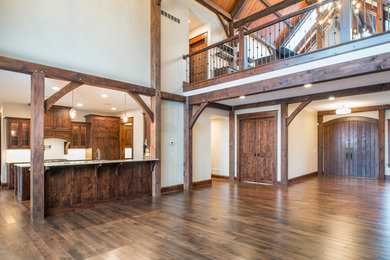 Large mountain style u-shaped medium tone wood floor and brown floor kitchen photo in Other with a farmhouse sink, shaker cabinets, medium tone wood cabinets, granite countertops, beige backsplash, subway tile backsplash, stainless steel appliances and an island