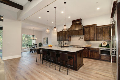Open concept kitchen - transitional u-shaped light wood floor open concept kitchen idea in Sacramento with an undermount sink, shaker cabinets, dark wood cabinets, granite countertops, beige backsplash, stainless steel appliances and an island