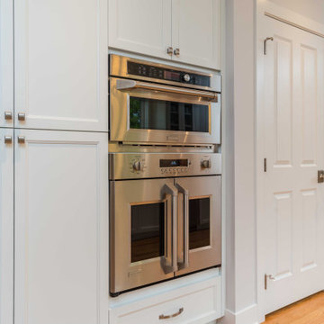 Modern Kitchen with White Flat Panel Shaker Cabinets & Natural Stone Backsplash