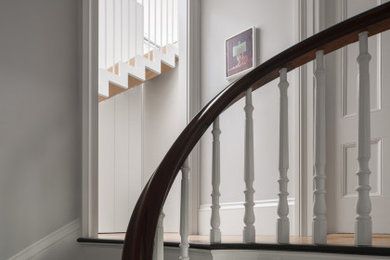 На фото: лестница в современном стиле с крашенными деревянными ступенями, крашенными деревянными подступенками и деревянными перилами