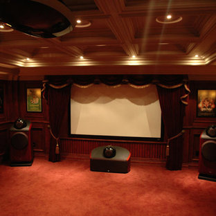 Idées déco pour une grande salle de cinéma classique fermée avec un mur rouge, moquette, un écran de projection et un sol orange.