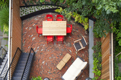 Inspiration for a small eclectic backyard patio in New York with brick pavers.