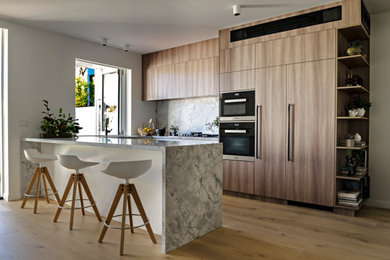 This is an example of a mid-sized contemporary u-shaped eat-in kitchen in Melbourne with white cabinets.