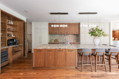 Large trendy l-shaped medium tone wood floor and brown floor open concept kitchen photo in Denver with an undermount sink, flat-panel cabinets, medium tone wood cabinets, terrazzo countertops, gray backsplash, stone slab backsplash, paneled appliances, an island and gray countertops