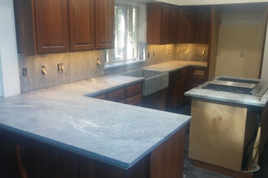 Photo of an eat-in kitchen in San Francisco with a farmhouse sink, soapstone benchtops and with island.