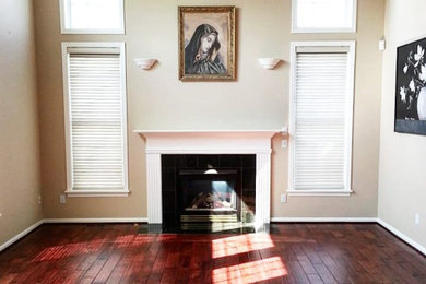 Living room - mid-sized traditional enclosed medium tone wood floor living room idea in New York with beige walls, a standard fireplace, no tv and a tile fireplace