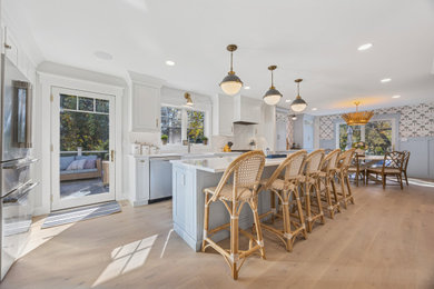 Large beach style light wood floor kitchen photo in Philadelphia with a farmhouse sink, shaker cabinets, blue cabinets, quartz countertops, white backsplash, quartz backsplash, stainless steel appliances, an island and white countertops