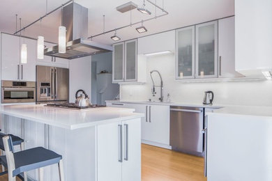 Eat-in kitchen - large contemporary u-shaped light wood floor eat-in kitchen idea in New York with an undermount sink, flat-panel cabinets, white cabinets, quartzite countertops, stainless steel appliances and an island
