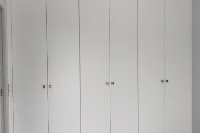 Ejemplo de armario y vestidor de mujer mediterráneo de tamaño medio con a medida, armarios con paneles lisos, puertas de armario de madera clara, suelo de baldosas de cerámica, suelo beige y casetón