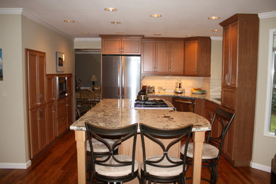 Example of a classic dark wood floor and brown floor kitchen design in Seattle with shaker cabinets, dark wood cabinets, subway tile backsplash and stainless steel appliances