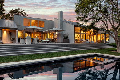 Inspiration for a large contemporary gray two-story wood exterior home remodel in Santa Barbara with a shed roof