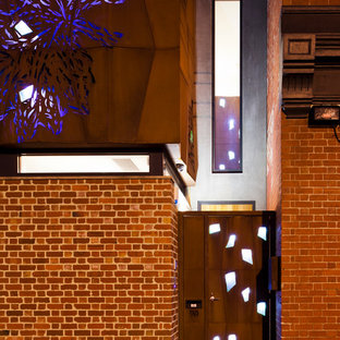 Foto di una grande porta d'ingresso design con pareti con effetto metallico, pavimento in legno massello medio, una porta singola e una porta in metallo