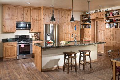 Inspiration for a mid-sized craftsman single-wall medium tone wood floor open concept kitchen remodel in Other with a single-bowl sink, shaker cabinets, light wood cabinets, granite countertops, stone slab backsplash, stainless steel appliances and an island