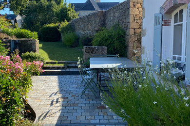 Cette image montre une petite terrasse avant marine avec des pavés en pierre naturelle.