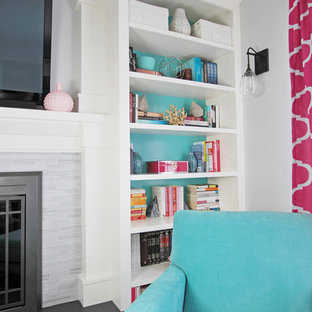 Modern home office and library in Philadelphia with grey walls, light hardwood flooring, a standard fireplace, a tiled fireplace surround and a freestanding desk.