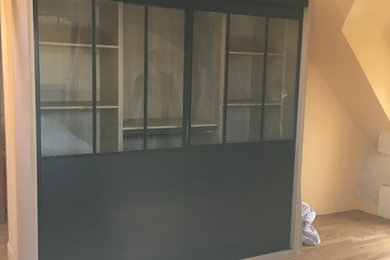 Exemple d'un placard dressing chic de taille moyenne et neutre avec un placard à porte affleurante et des portes de placard noires.