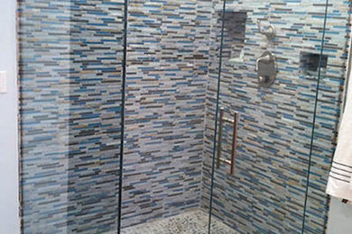 Example of a large master multicolored tile and ceramic tile light wood floor corner shower design in Denver with beige walls