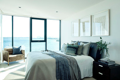 Large contemporary master bedroom in Perth with white walls, carpet and beige floor.