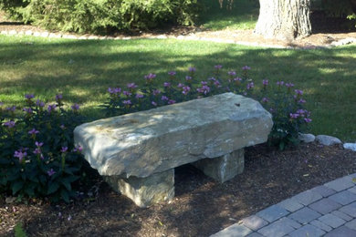 Réalisation d'un jardin latéral tradition avec pierres et graviers et des pavés en brique.