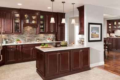 Example of a classic ceramic tile eat-in kitchen design in DC Metro with an undermount sink, raised-panel cabinets, dark wood cabinets, solid surface countertops, glass tile backsplash, stainless steel appliances and an island