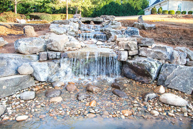 Design ideas for a mid-sized traditional partial sun backyard stone water fountain landscape in Atlanta.