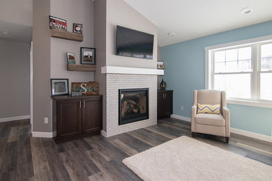 Photo of a mid-sized transitional open concept living room in Milwaukee with grey walls, vinyl floors, a standard fireplace, a tile fireplace surround and a wall-mounted tv.