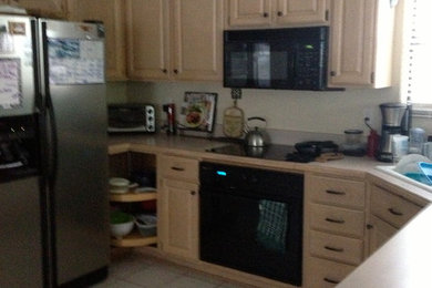 Mid-sized beach style single-wall porcelain tile open concept kitchen photo in Jacksonville with an undermount sink, raised-panel cabinets, beige cabinets, quartzite countertops, stainless steel appliances and an island
