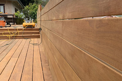 Deck - large contemporary backyard ground level privacy and wood railing deck idea in Orange County with no cover
