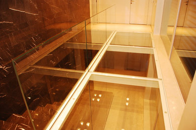 Foto di una scala a rampa dritta con pedata in marmo e parapetto in vetro