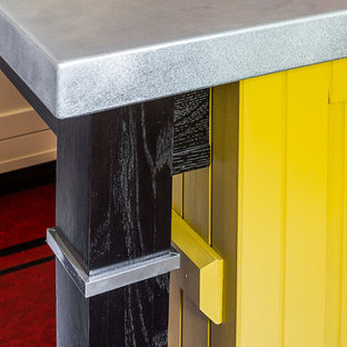 Mittelgroße Urige Küche in L-Form mit Vorratsschrank, Unterbauwaschbecken, Schrankfronten im Shaker-Stil, gelben Schränken, Granit-Arbeitsplatte, Küchenrückwand in Weiß, Rückwand aus Keramikfliesen, weißen Elektrogeräten, Linoleum, Kücheninsel, rotem Boden und schwarzer Arbeitsplatte in Sonstige