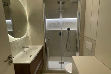 Cette photo montre une petite salle d'eau beige et blanche tendance avec WC suspendus, un carrelage beige, un plan vasque, un plan de toilette blanc, buanderie, meuble simple vasque et meuble-lavabo encastré.