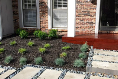Photo of a mid-sized contemporary front yard partial sun garden in Kansas City with natural stone pavers.
